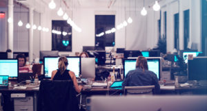 Professional team of employees working at desks in modern office