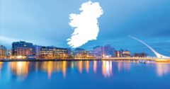 Dublin city skyline at dusk, with a white silhouette of Ireland against sky backdrop