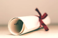 A degree scroll tied up with red ribbon on table