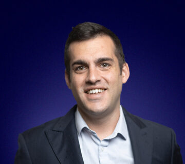 Tommaso Lugli, Head of Research and Strategic Accounts, dressed in a dark suit and smiling