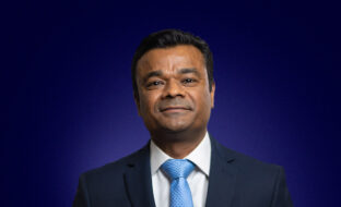 Snehal Wadhar, Chief Financial Officer, dressed in a suit and blue tie, smiling
