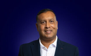 Les D'silva, Strategic Accounts, a suited professional man, smiling at camera