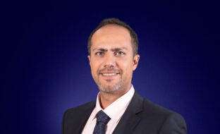 Edouard Senhaji, Head of Sophis Services, a dark-haired professional smiling at the camera against a wide blue header