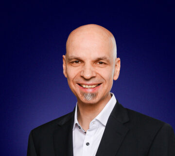 Christoph Steigemann, Head of Managed Services, dressed in a dark suit, smiling at the camera