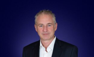 Headshot of Paul Beeke, Strategic Advisor, in front of blue background