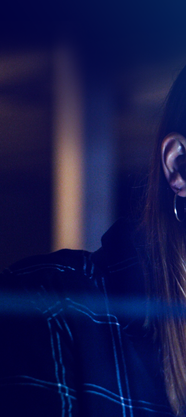 Female professional in glasses glancing at reflection of laptop screen in office environment